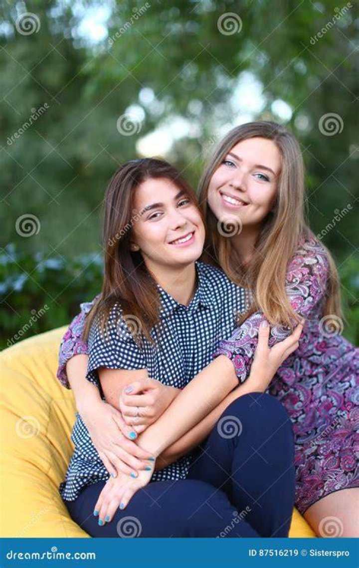two women sitting next to each other in front of a window with the